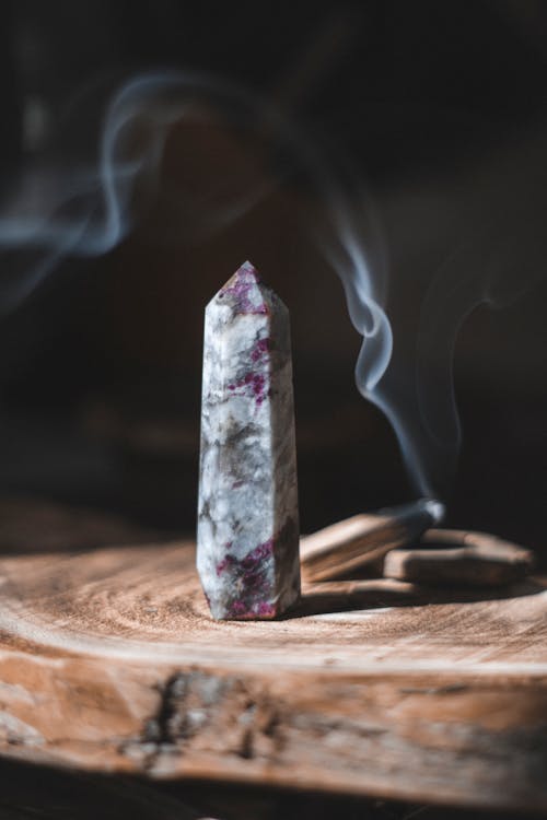 Free A purple crystal on top of a wooden stick Stock Photo